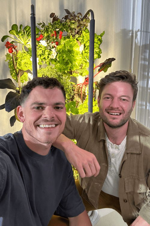 Two men sitting in front of a Hydrogrowhub Home system.